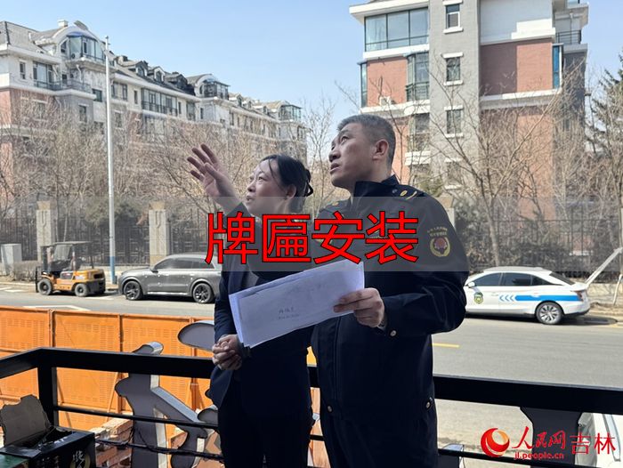朝阳区城市管理行政执法局工作人员正上门为商户讲解牌匾安装注意事项。人民网记者 李思玥摄